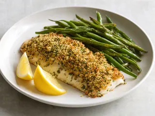 Barramundi con costra de macadamias, ejotes asados y gajos de limón