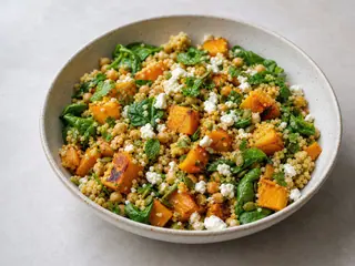 Ensalada australiana de calabaza y cuscús con feta, garbanzos, espinaca, hierbas y pepitas
