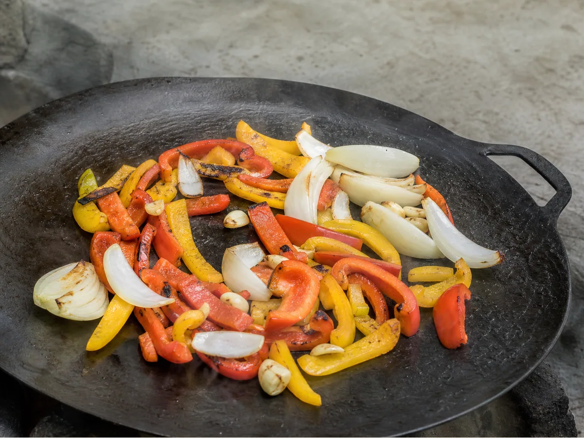 Cebollas y pimientos morrones ampollados con ajo aromático para el saj azerbaiyano de cordero