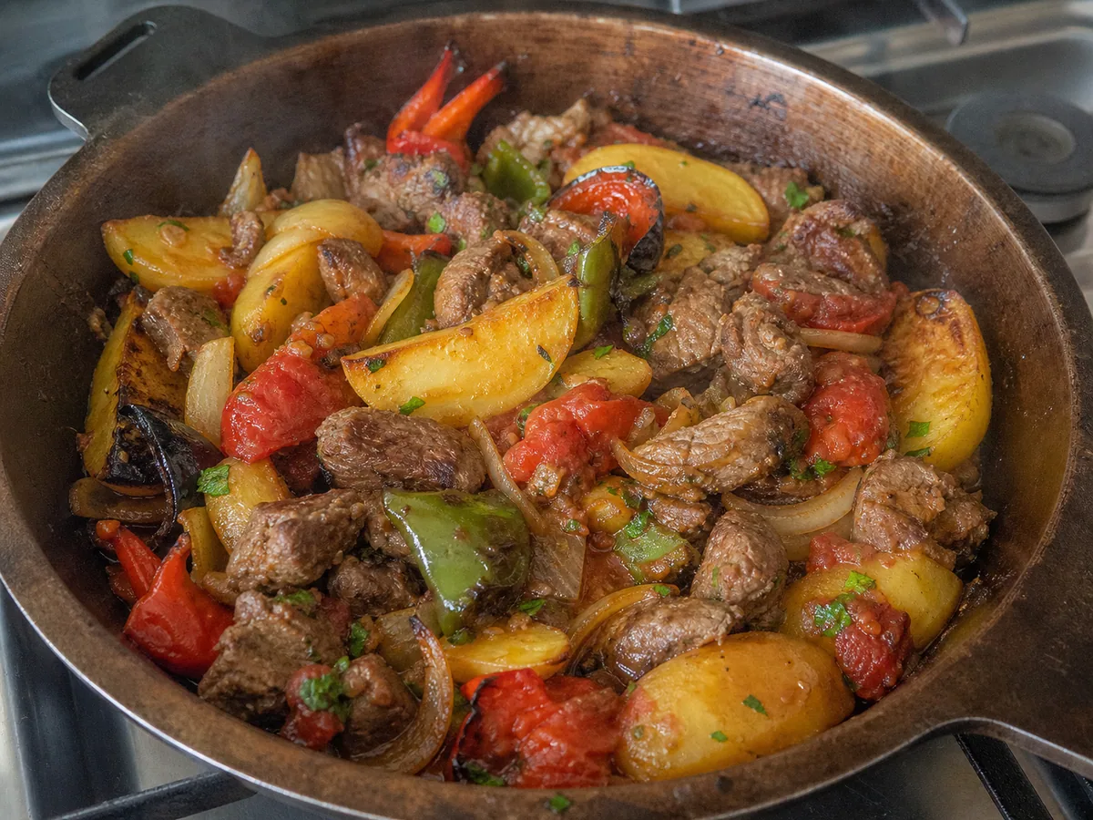 Cordero completamente cocido, papas doradas, pimientos, cebollas y tomates combinados en un saj azerbaiyano de cordero