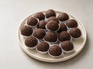 Brazilian brigadeiros coated in chocolate sprinkles and set in paper candy cups