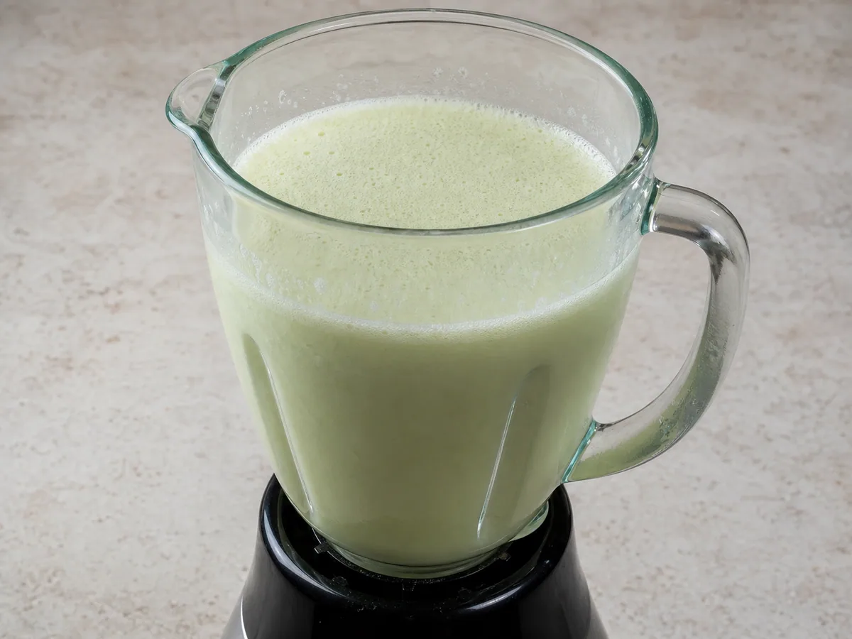 Limonada brasileña verde pálido con espuma fina y uniforme en la licuadora después de licuar