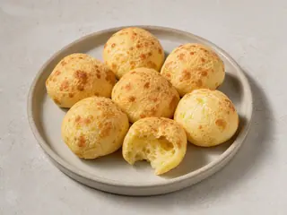 Basket of warm Brazilian pão de queijo with crisp golden shells