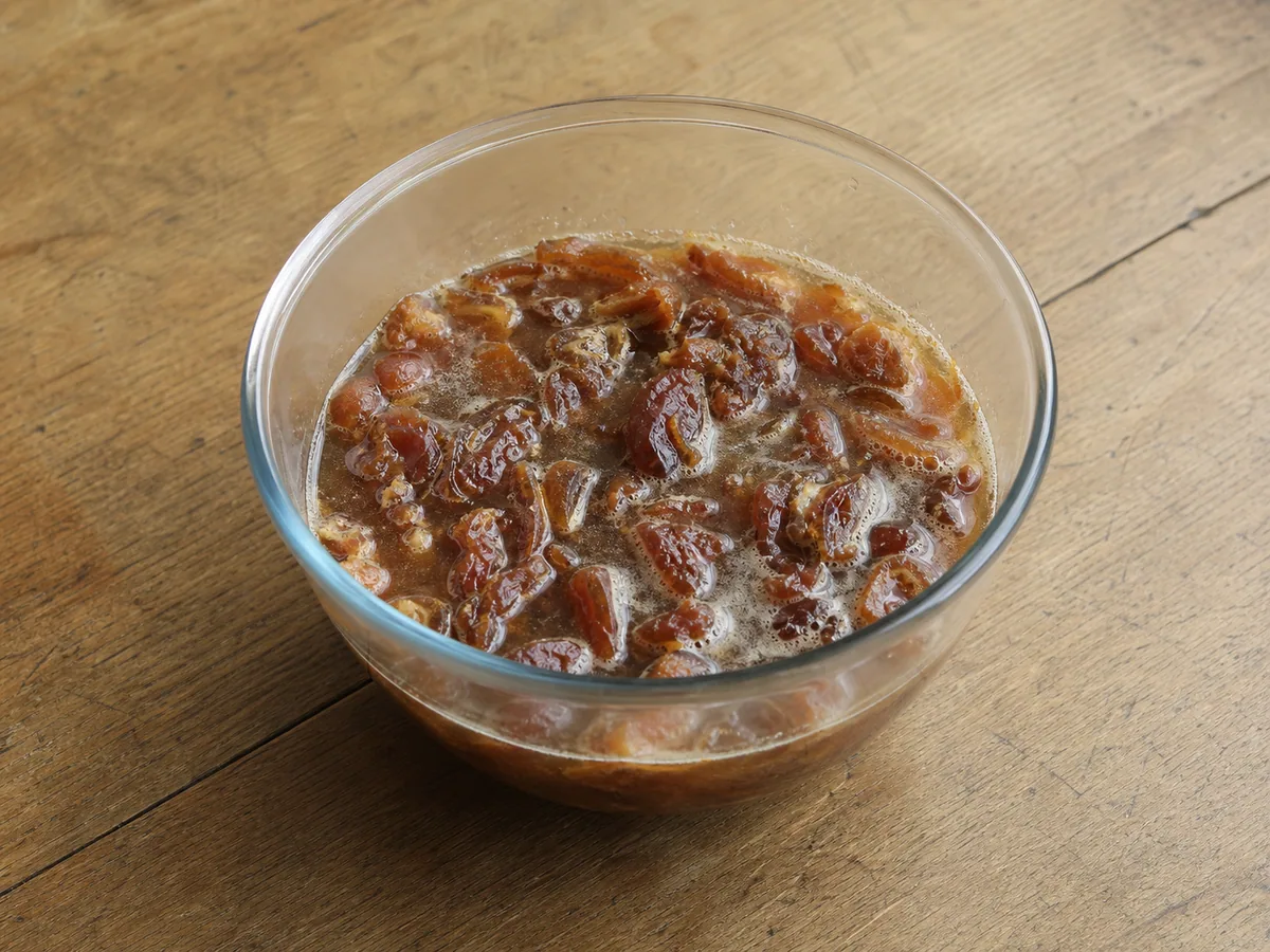 Tâmaras picadas e amolecidas em líquido espesso para o pudim britânico de toffee