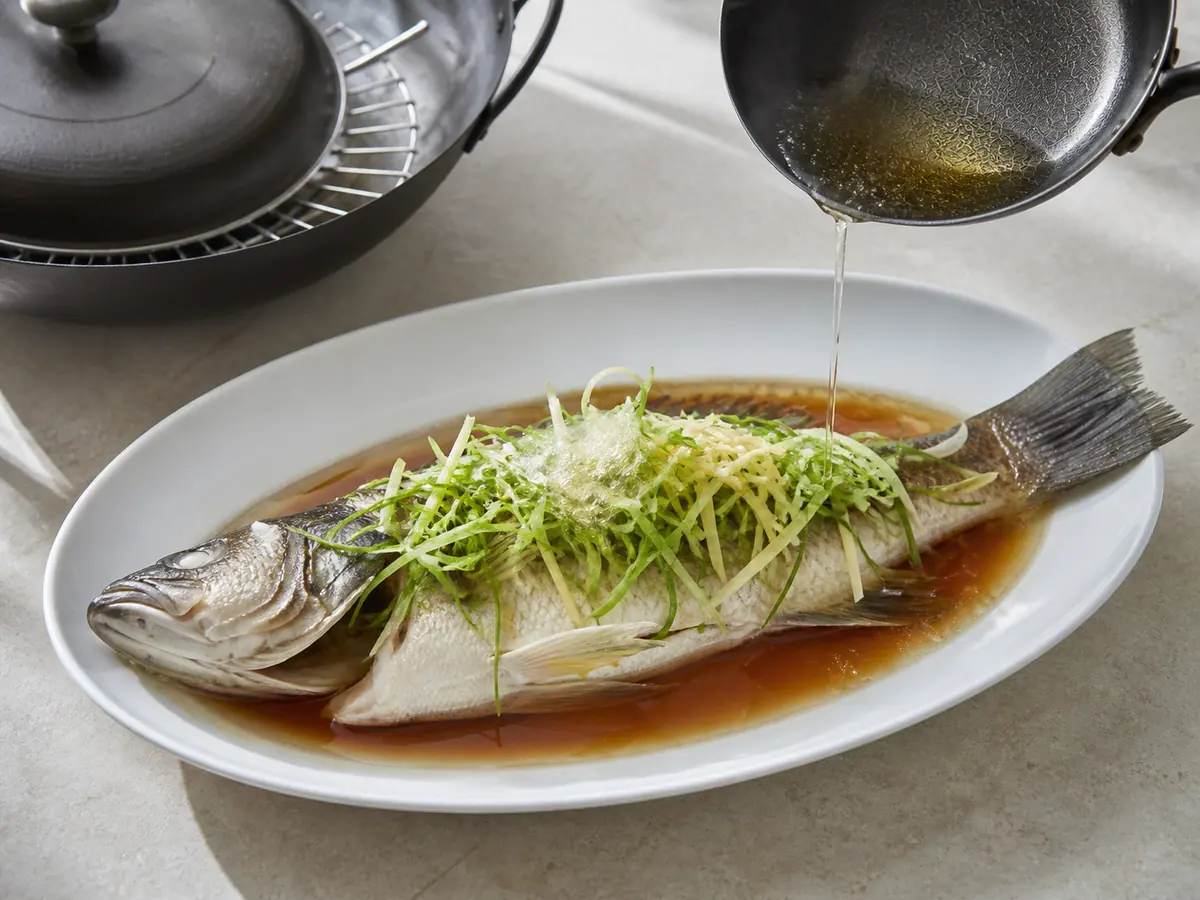 Cantonese steamed fish finished with sizzling ginger, scallions, soy sauce, and hot oil