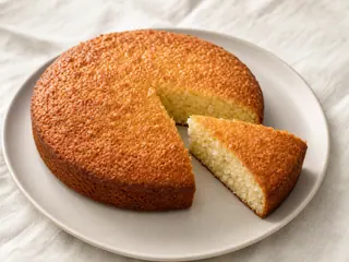 Golden round Caribbean coconut bake cut to show its soft coconut crumb