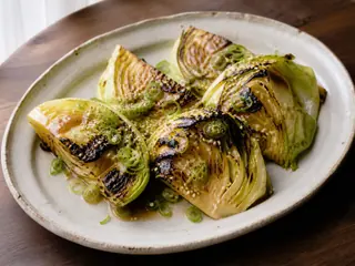 Charred cabbage wedges glazed with miso butter and topped with sesame and scallions