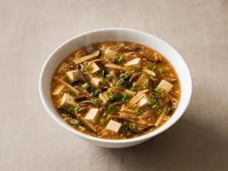 Tigela de sopa chinesa agripicante de tofu, com cogumelos e cebolinha