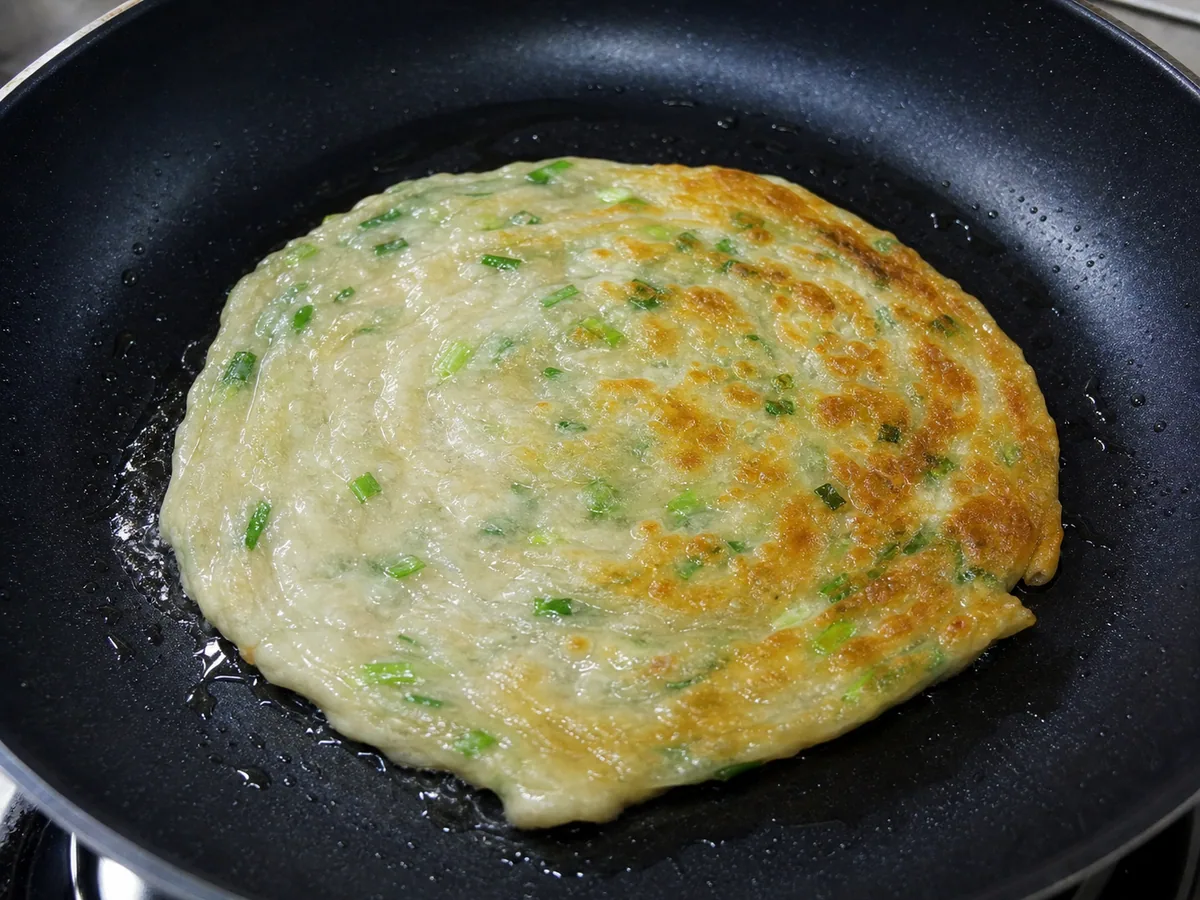 Panqueca fritando até dourar e ficar crocante durante o preparo