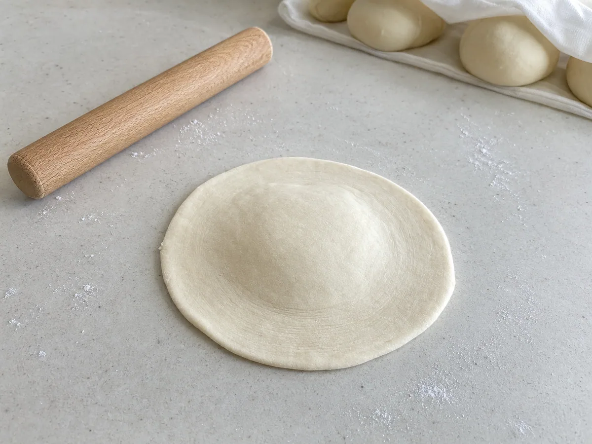 Bao dough wrapper rolled with thin edges and a thicker center