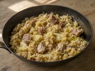 Tigela de cevada e repolho estonianos na frigideira com carne suína, chucrute, cevada-pérola e endro