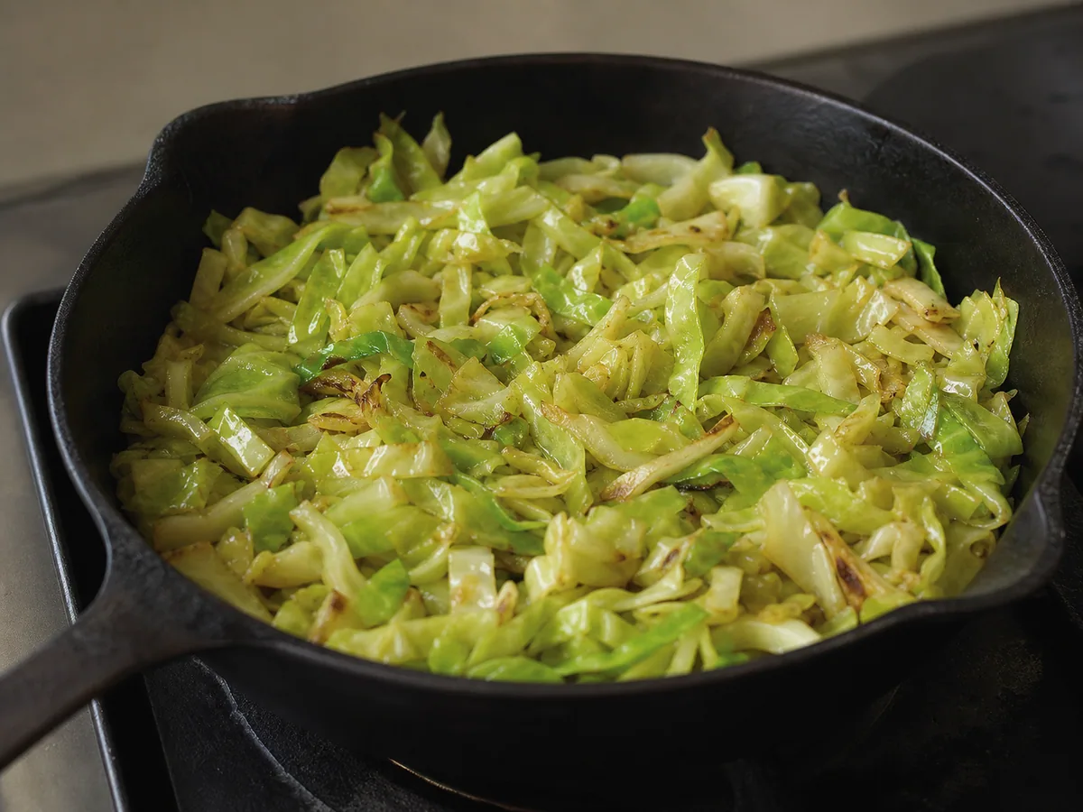 Green cabbage ribbons wilted by half with a few lightly browned edges for Estonian barley and cabbage skillet