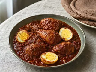 Ethiopian doro wat with chicken and halved fully cooked eggs in a deep red berbere sauce
