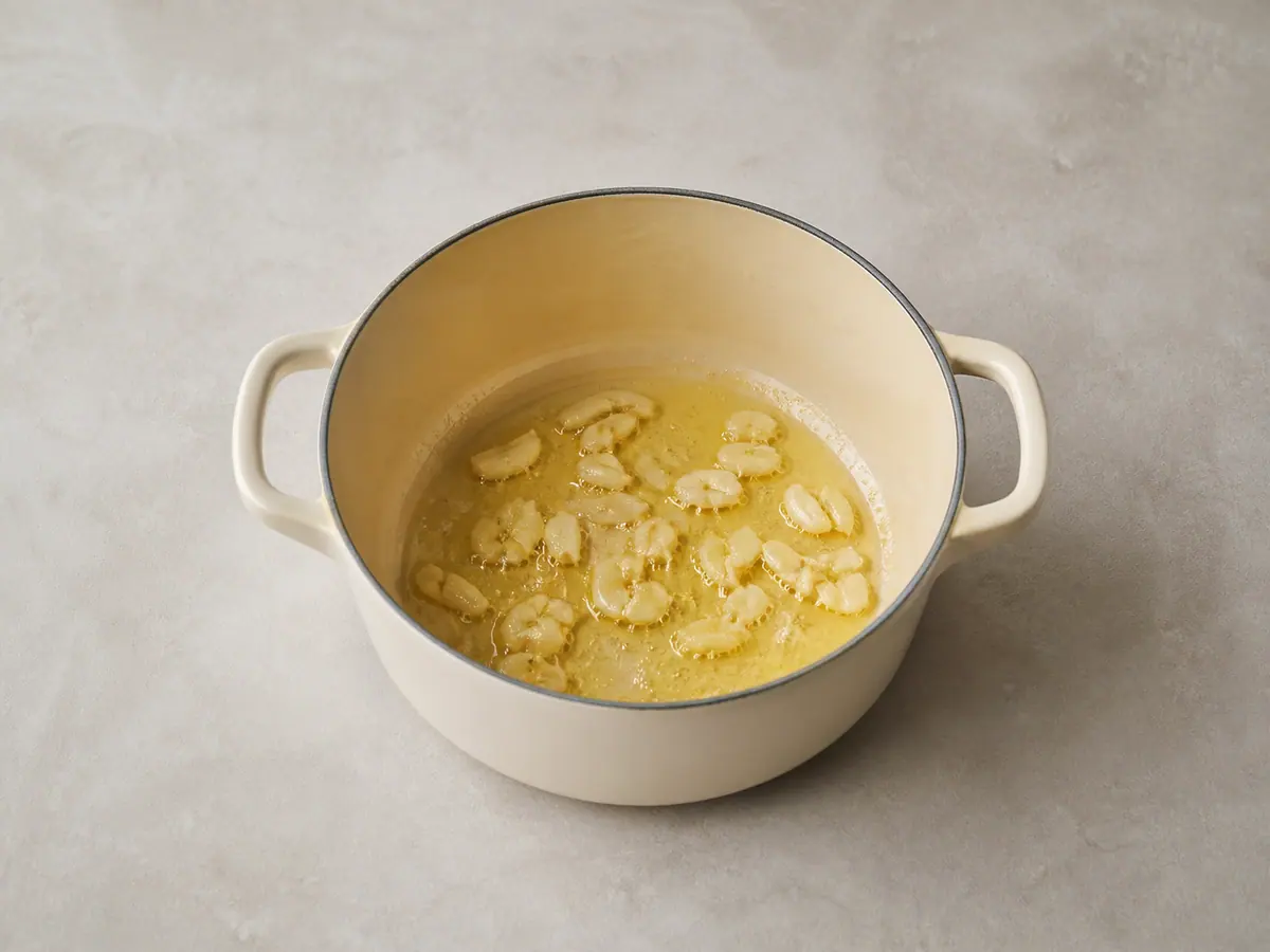 Crushed garlic blooming in hot oil in the adobo pot