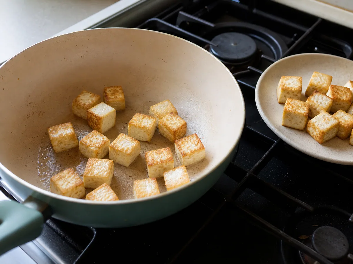 Cubos de tofu dourados em uma panela larga para laing filipino