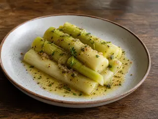 Mitades de puerro braseadas con vinagreta de mostaza, alcaparras y perejil