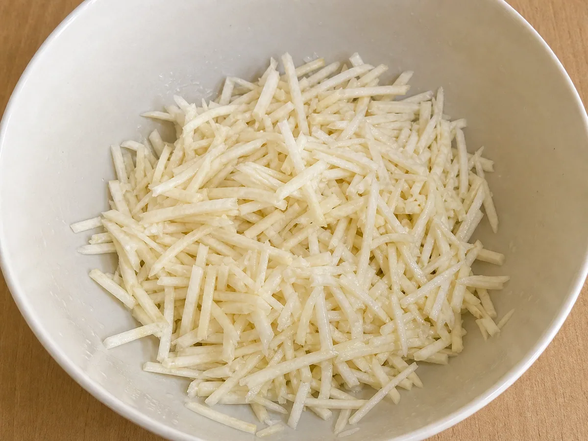 Fine celeriac matchsticks coated with lemon juice before dressing