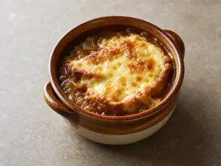 Sopa de cebolla francesa cubierta con baguette y queso Gruyère burbujeante