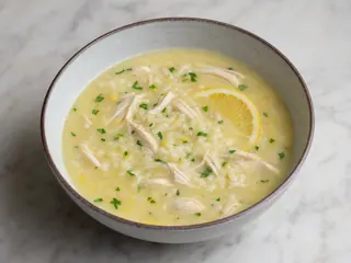 Bowl of Greek avgolemono chicken soup with rice, lemon, and fresh dill