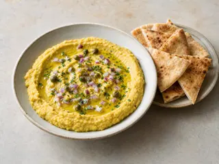 Greek yellow split pea fava dip topped with capers and red onion, served with toasted pita wedges