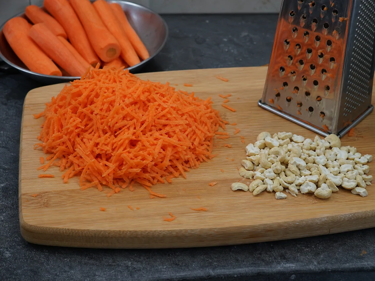 Distinct grated carrot shreds and coarsely chopped cashews prepared for Indian carrot halwa