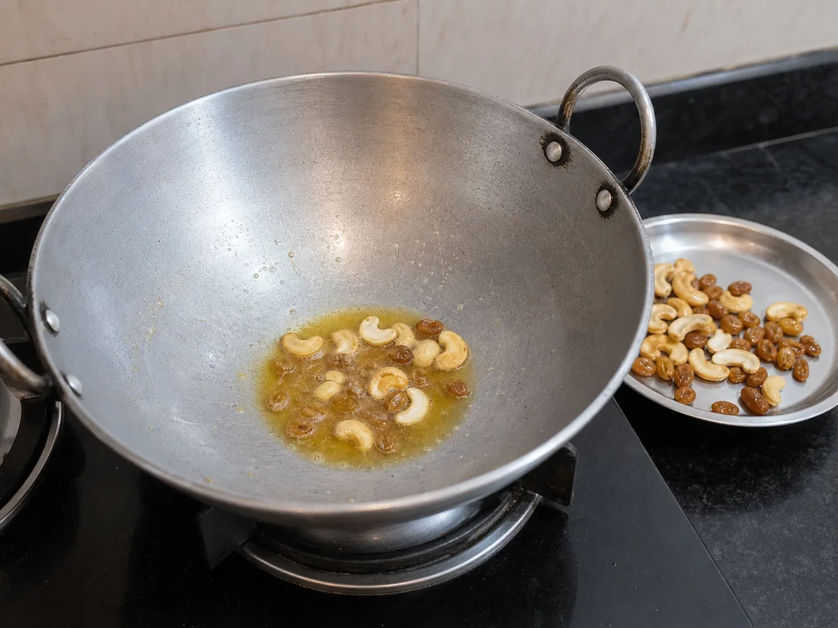 Cashews lightly toasted and raisins plumped in ghee for Indian carrot halwa