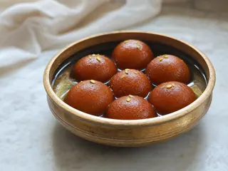 Gulab jamun en almíbar de cardamomo y agua de rosas con pistachos picados