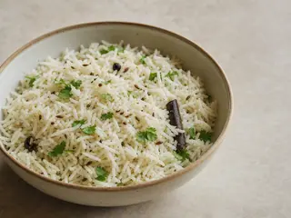 Tazón de arroz jeera indio esponjoso con semillas de comino tostadas y cilantro
