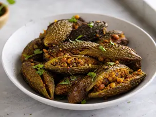 Melones amargos rellenos y dorados en sartén, con masala dorado de chana dal