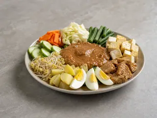 Indonesian gado-gado salad with vegetables, tofu, tempeh, eggs, and peanut sauce