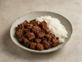 Tempeh rendang coated in a dark coconut spice sauce and served with rice