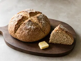 Pan de soda irleés redondo, con una cruz profunda y una porción cortada en forma de cuña