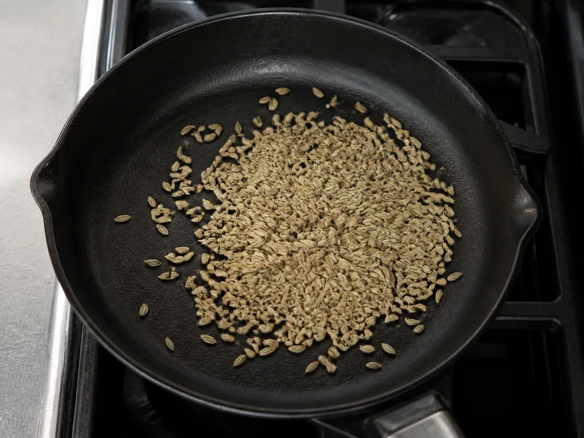 Semillas de hinojo color canela claro tostadas ligeramente en una sartén pequeña y seca