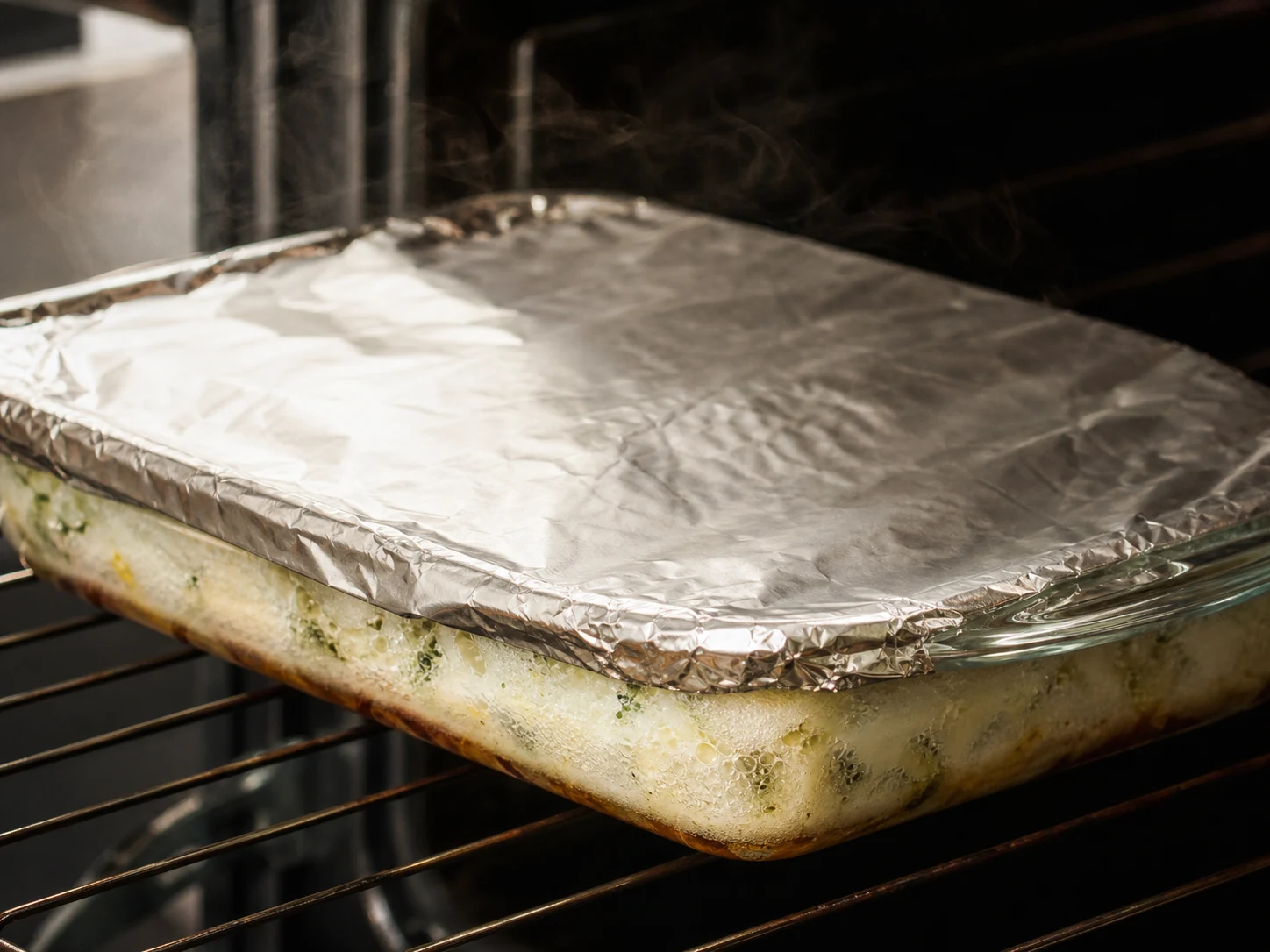 Covered-bake checkpoint with bubbling sauce and a center cannelloni nearly tender