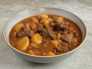Bowl of Jamaican Ital stew with kidney beans, sweet potato, squash, cabbage, and okra