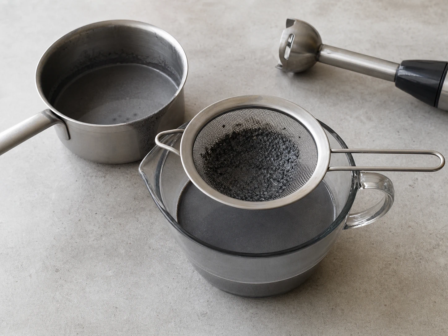 Smooth black sesame pudding base strained into a measuring jug