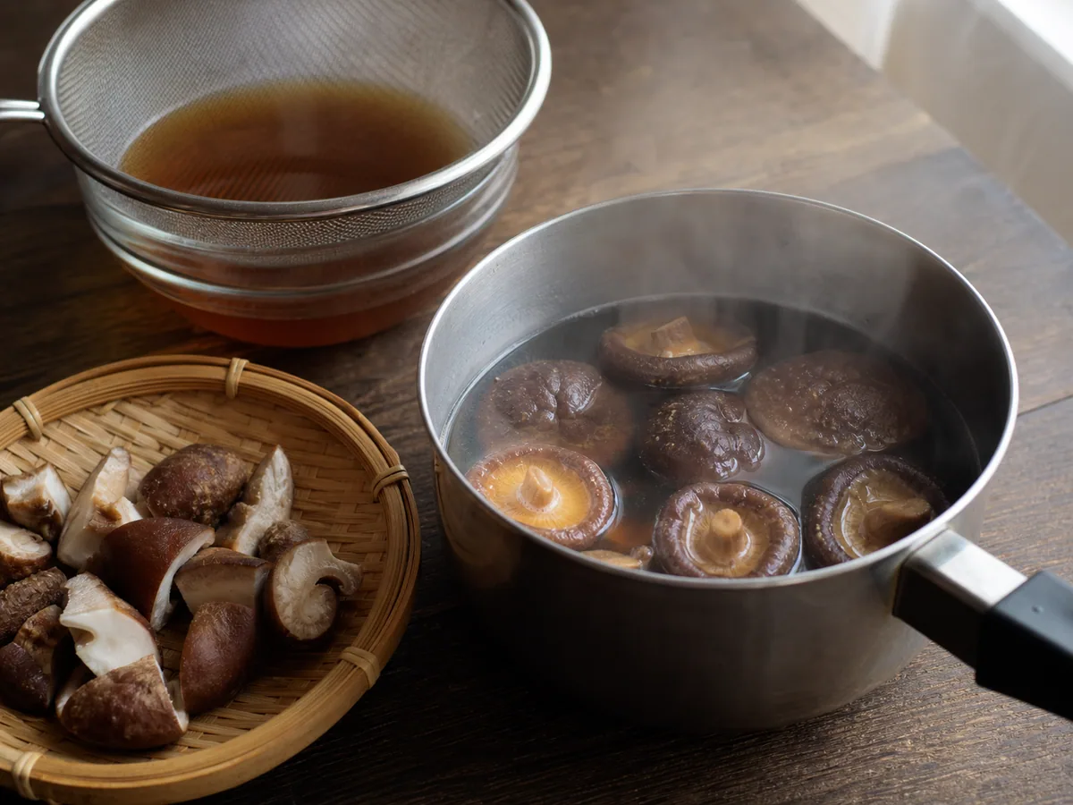 Chapéus de shiitake totalmente reidratados em dashi fumegante para chikuzenni japonês
