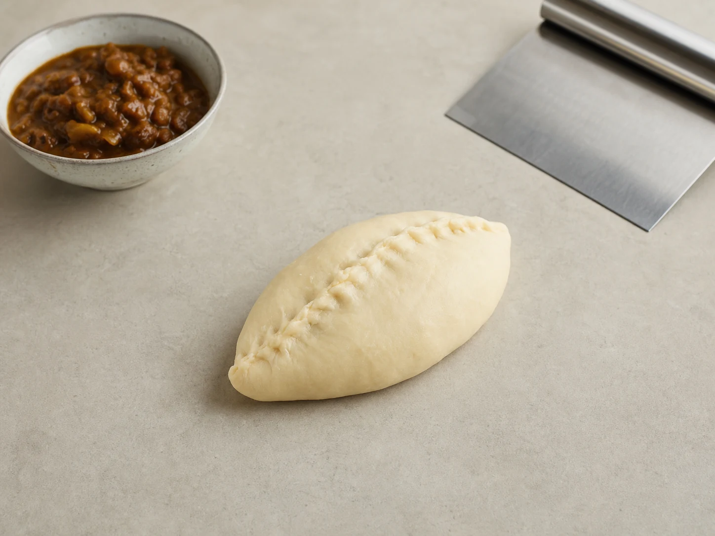 Sealed Japanese curry bread roll with a firmly pinched seam