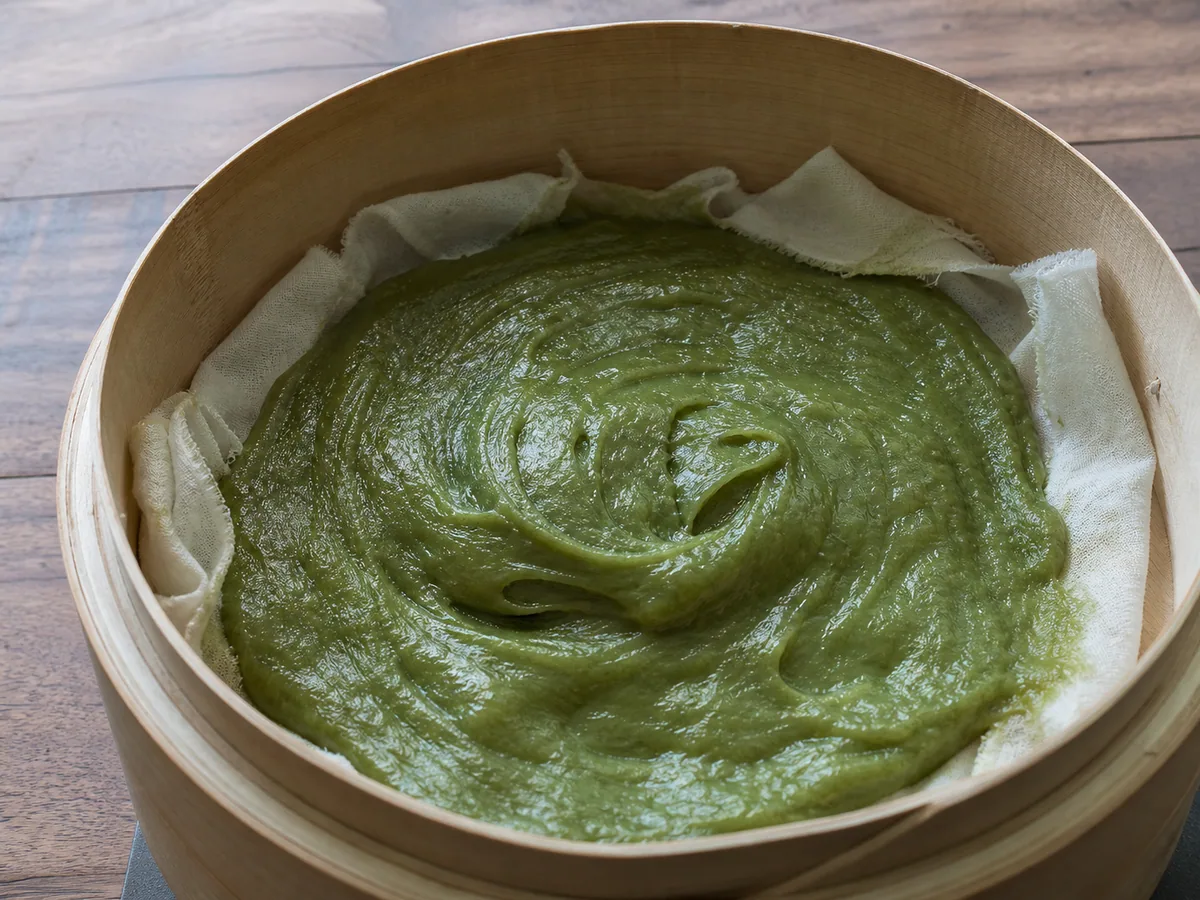 Massa de mochi de matcha totalmente cozida no vapor, brilhante e elástica na tigela resistente ao calor