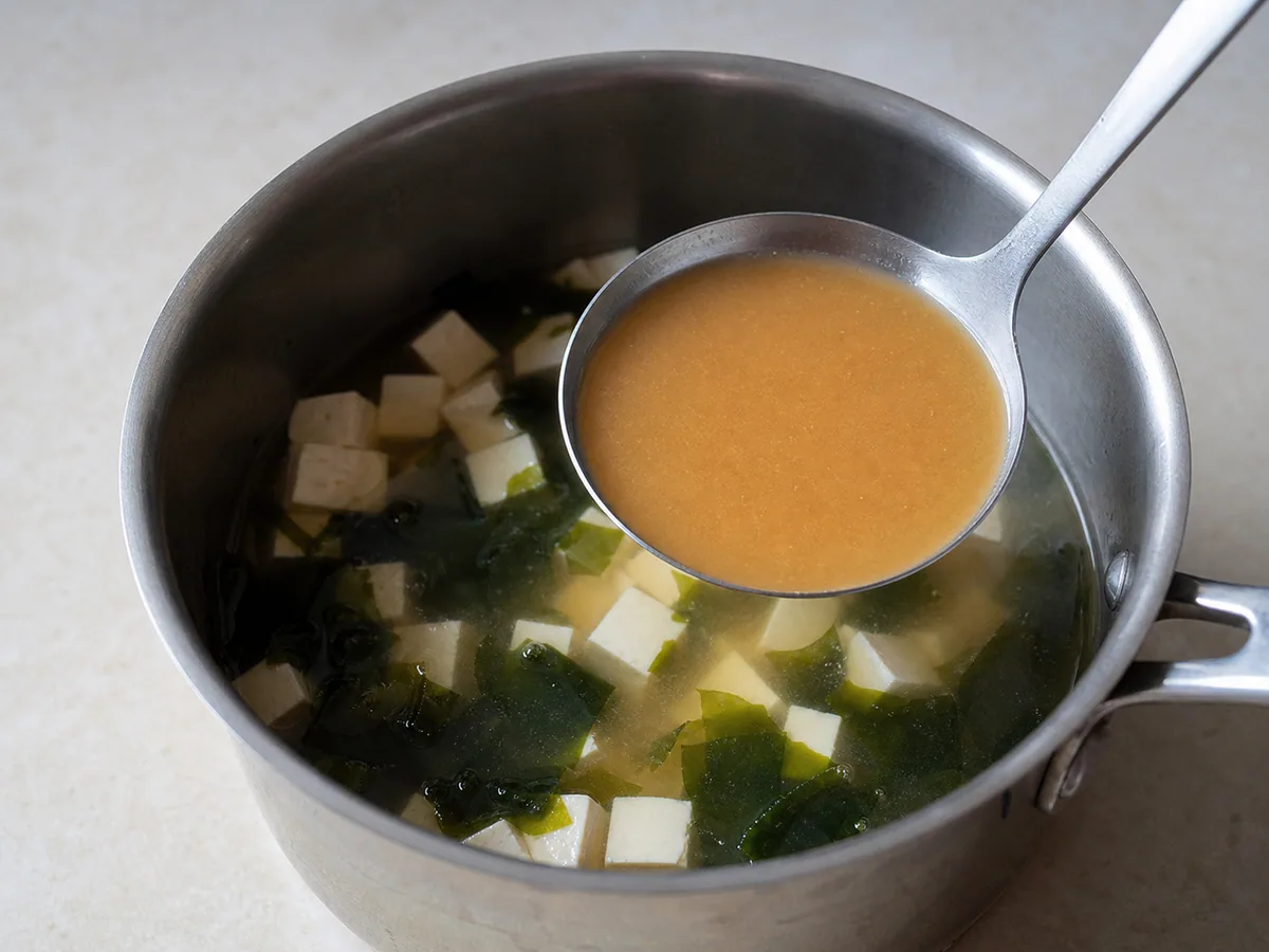 Missô dissolvido em um caldo liso dentro de uma concha sobre a sopa