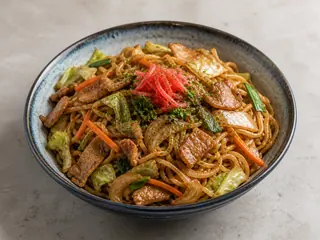 Plato de yakisoba japonés con repollo, cerdo, aonori y jengibre encurtido