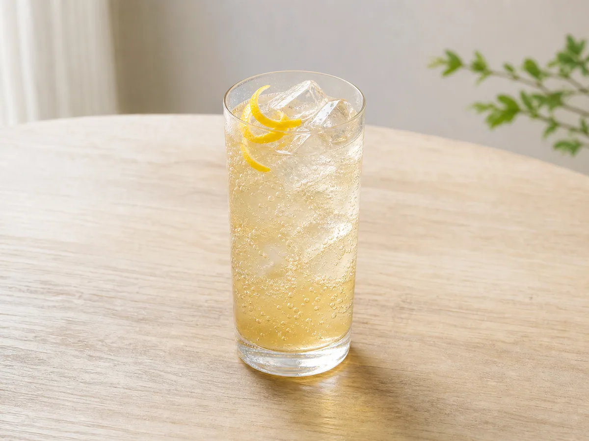 Tall glass of Japanese yuzu honey soda with ice and a curl of yuzu peel