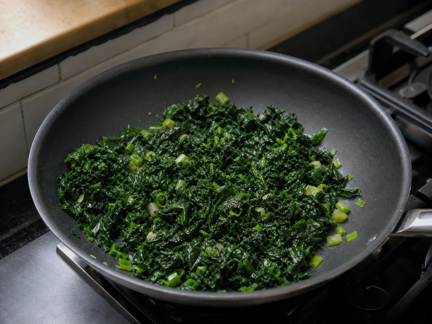 Dark green kale and softened scallions cooked until no liquid remains in the skillet