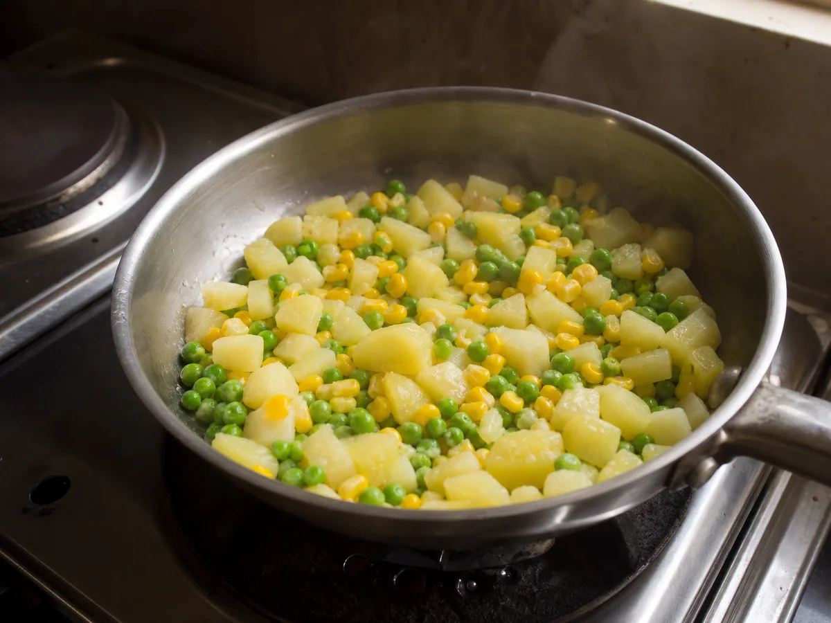 Potatoes, peas, and corn steam-dried until their surfaces look dry in a warm saucepan