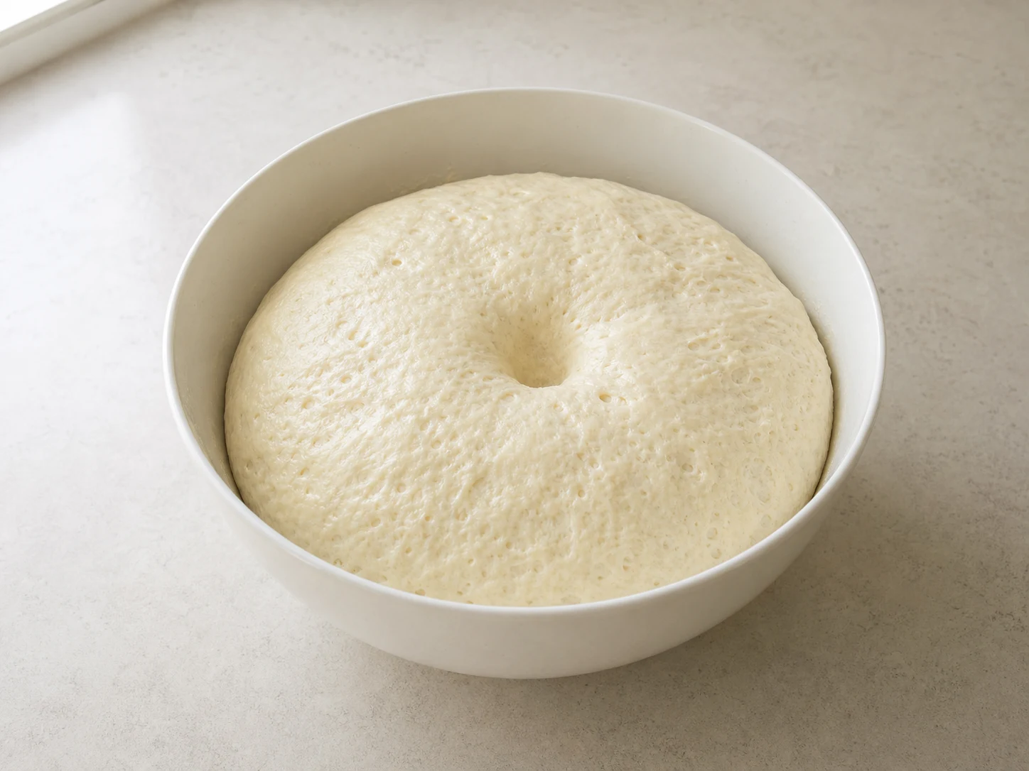 Masa de hotteok coreano levada, duplicada y aireada, con una hendidura poco profunda que indica que está lista
