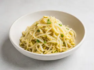 Namul coreano de brotes de soya decorado con cebollín y semillas de sésamo
