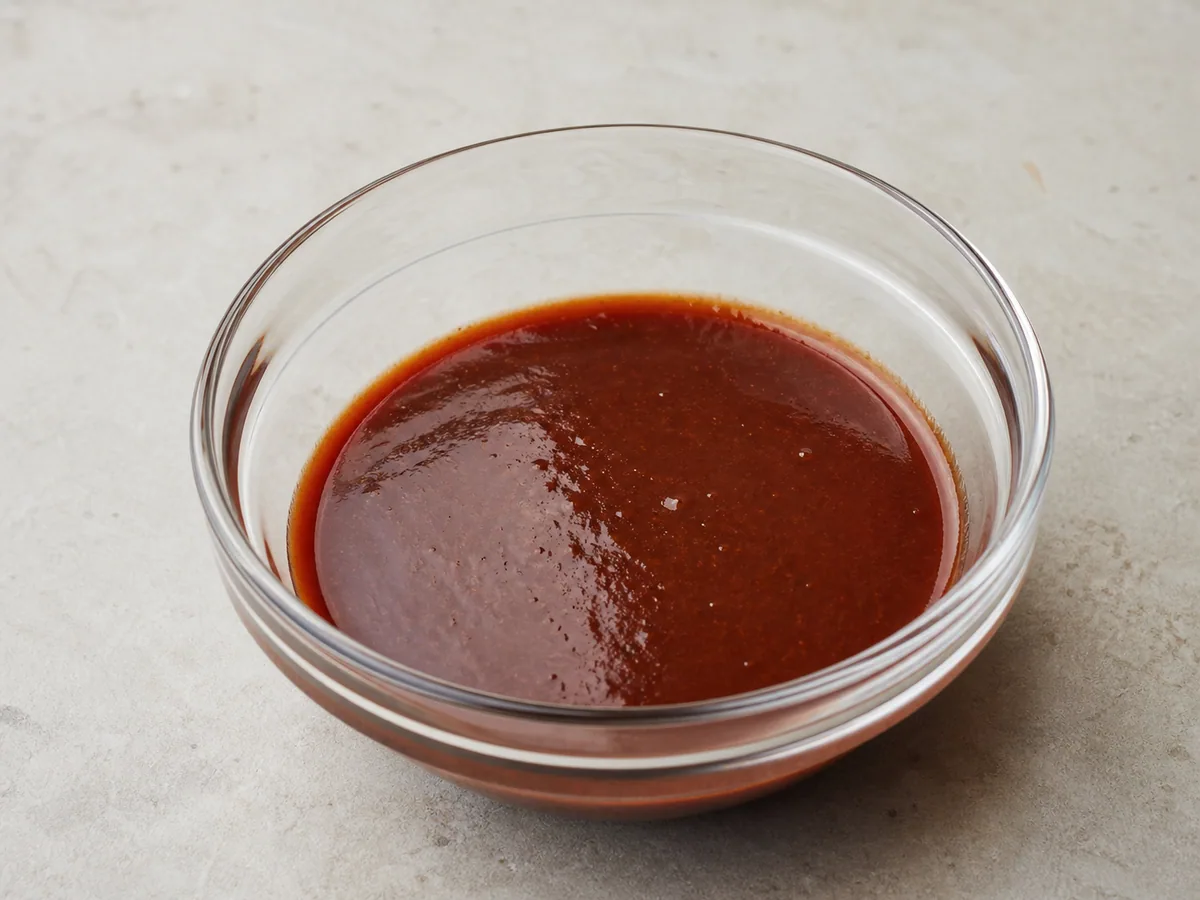 Repollo y cebolla parcialmente ableados a fuego lento en salsa roja de tteokbokki