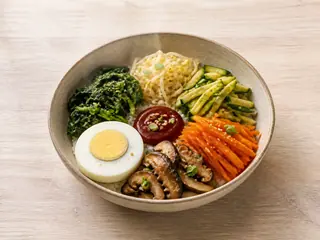 Bibimbap coreano de verduras con verduras coloridas, arroz y huevo completamente cocido