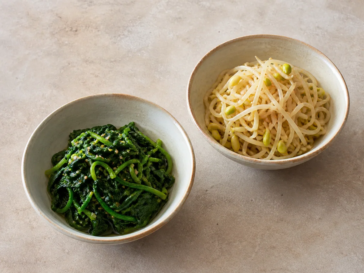 Espinaca y brotes de frijol mungo cocidos y sazonados en tazones separados para bibimbap coreano de verduras