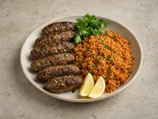 Rollos de kofta libanesa de res servidos con bulgur al tomate, perejil y limón